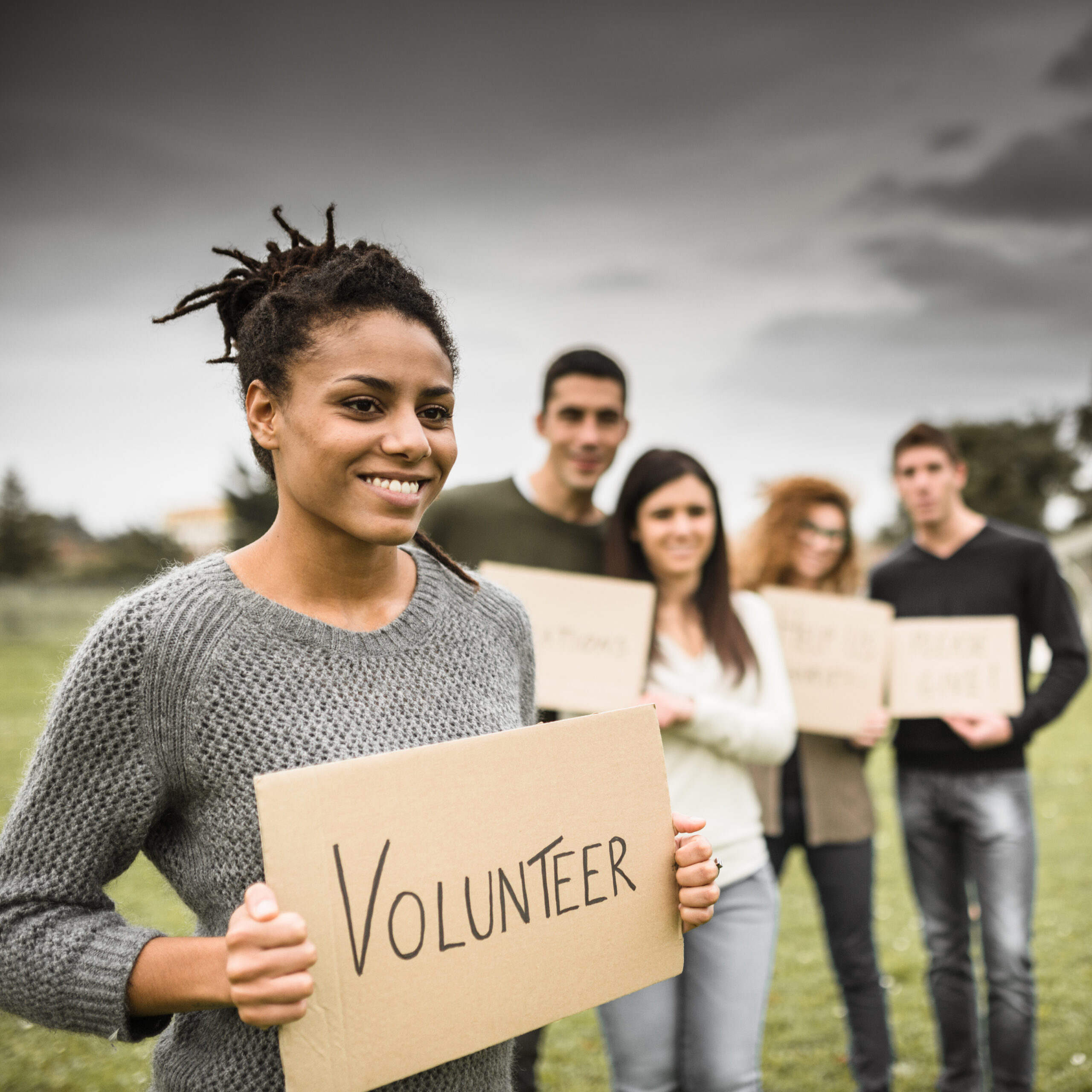 Group of Volunteers holding a Volunteer banner